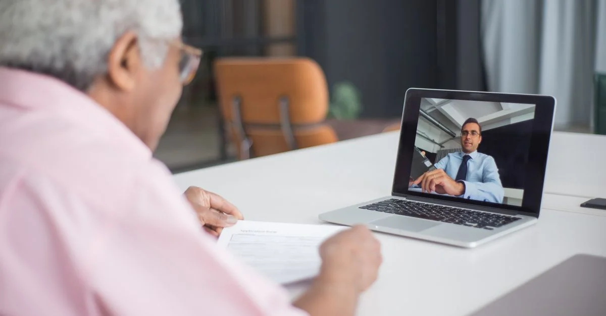 Senior discutant affaires lors d'un appel vidéo avec un consultant sur un ordinateur portable.