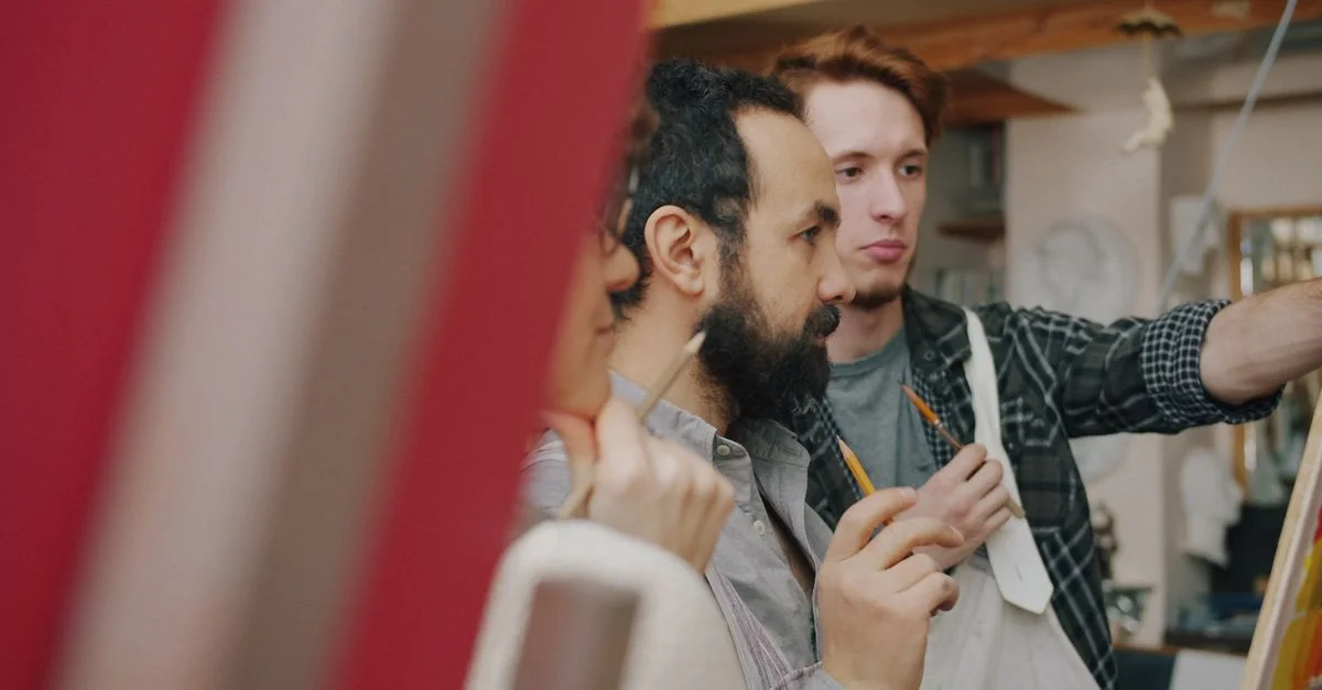 Deux artistes concentrés sur une œuvre d'art dans un atelier chaleureux.
