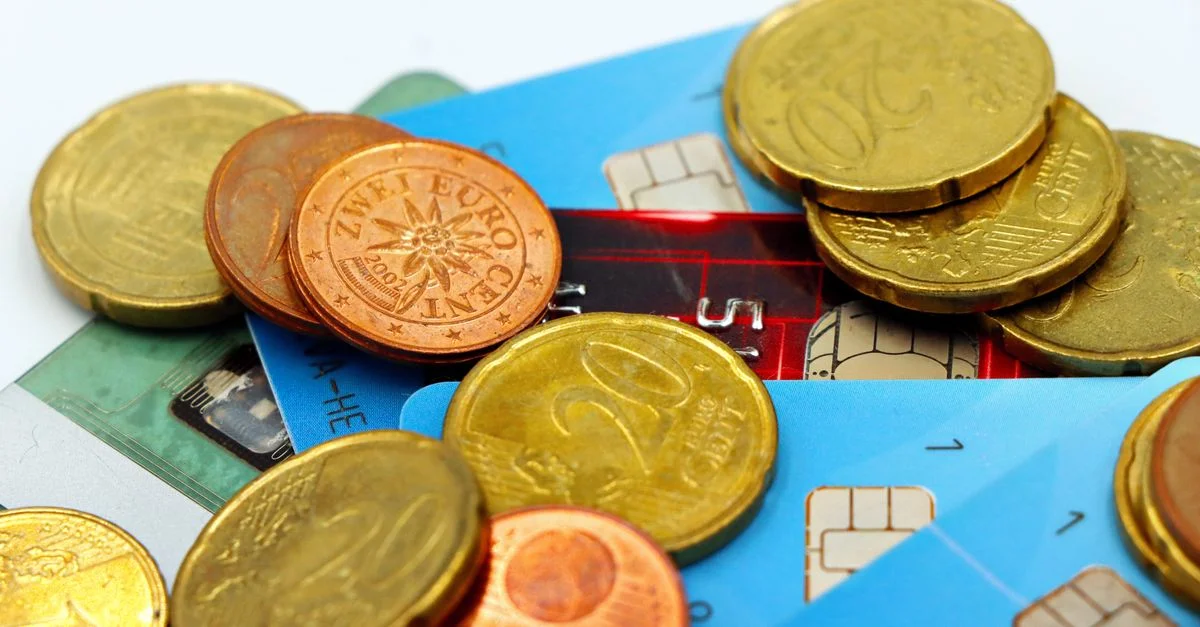 Gros plan sur des pièces en euros et des cartes de crédit représentant les transactions financières modernes.