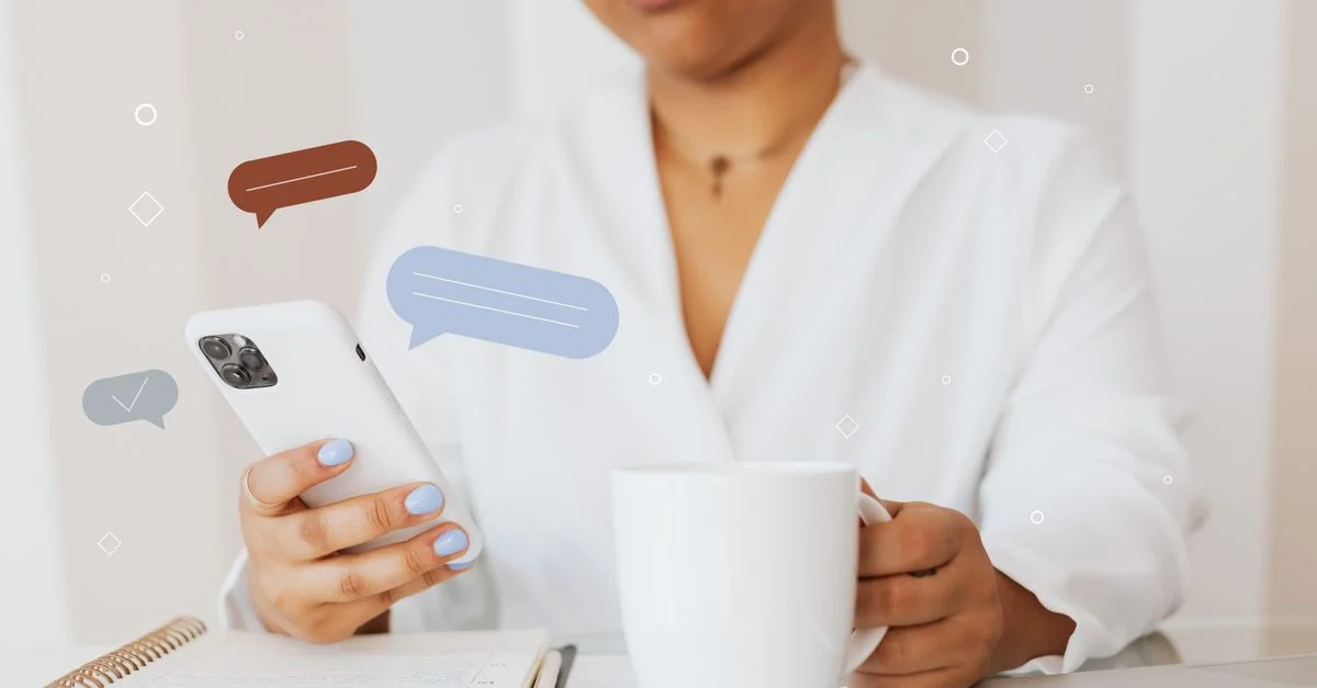 Gros plan d'une personne utilisant un smartphone tout en tenant une tasse de café, mettant en avant la communication numérique.